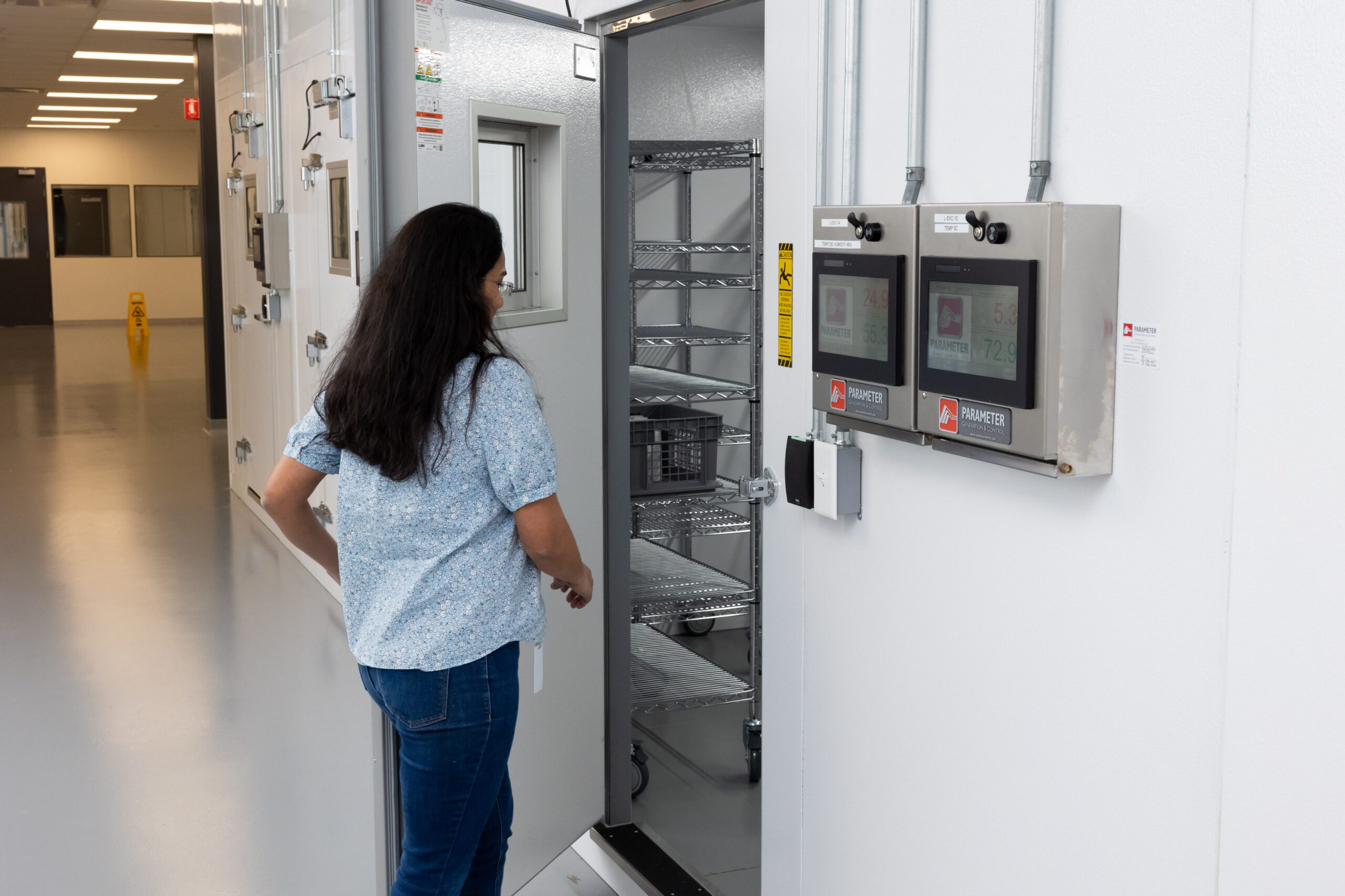 Scientist accessing ICH stability chambers for clinical trial material stability testing