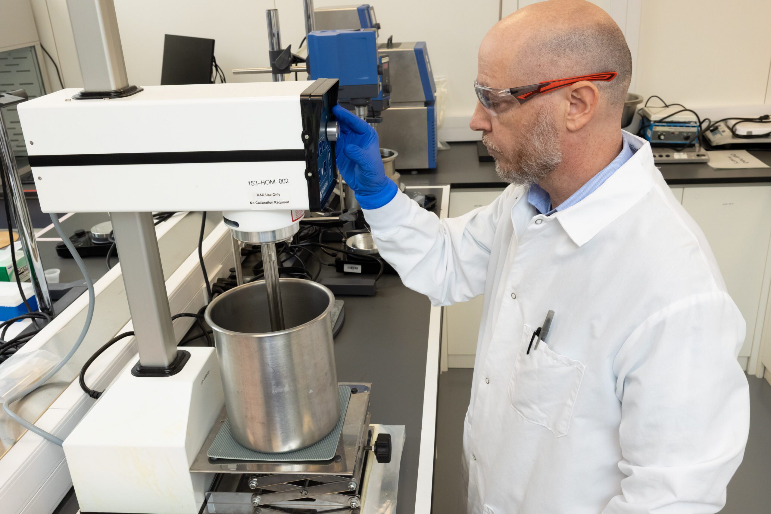 Scientist performing pharmaceutical process development and scale-up using bench-scale mixing equipment